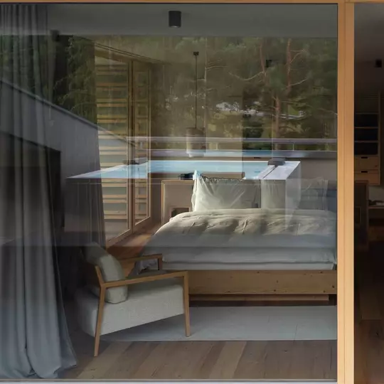 The view from outside a hotel room looking in at a solid timber bed frame and plush white bedding.