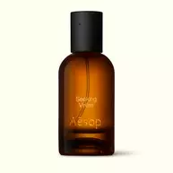Amber glass Aesop Seeking Virere Eau de Parfum bottle with black cap on a white background.